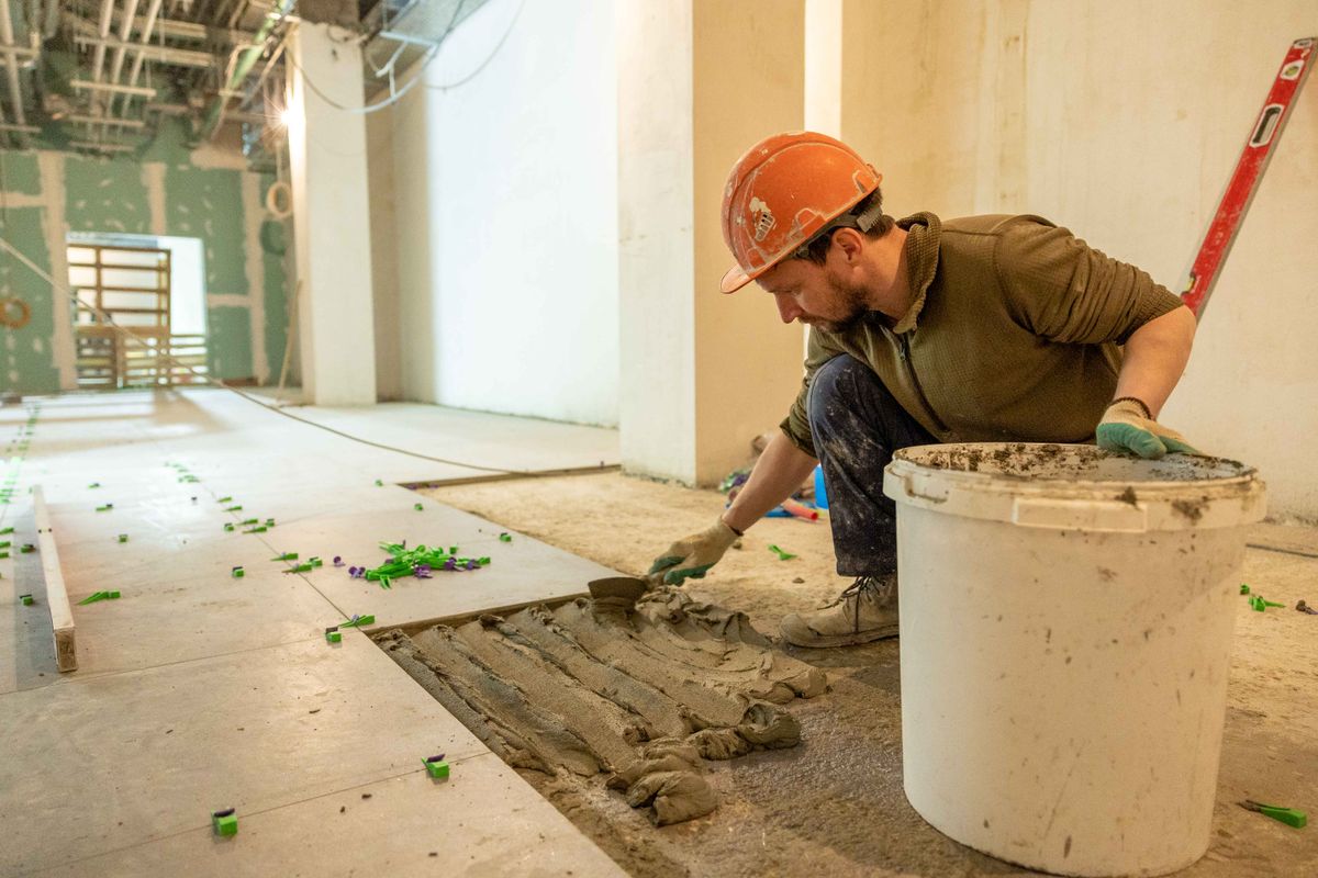 Professional installing tile flooring